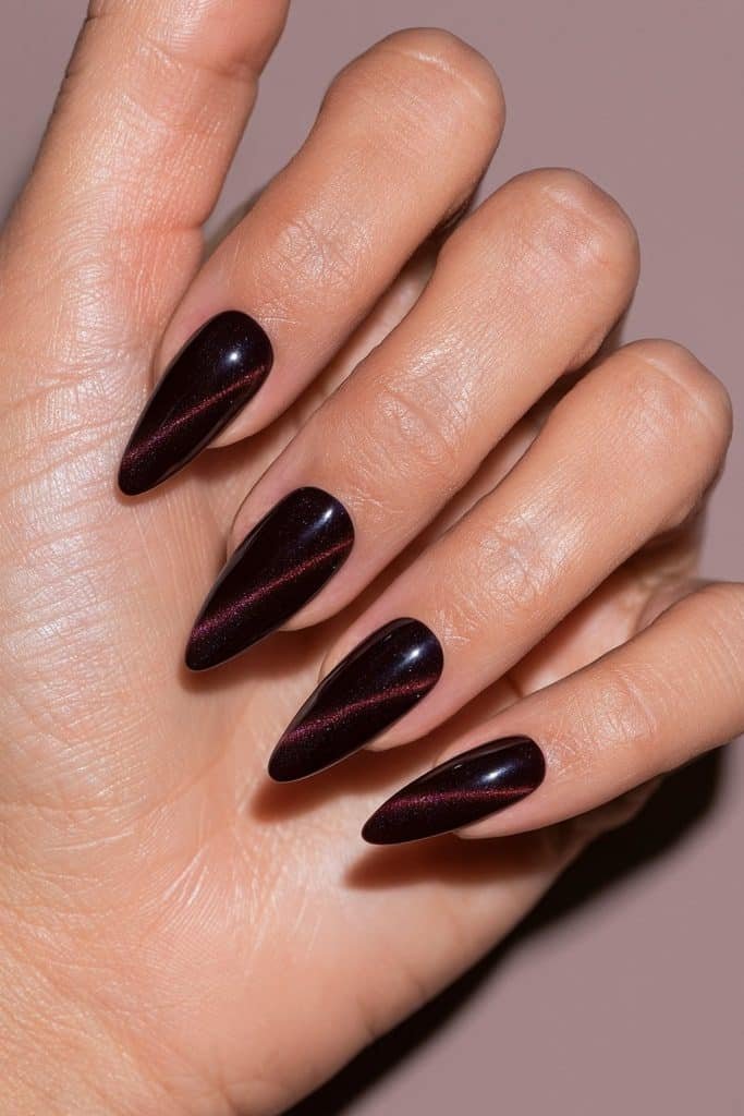 Maroon diagonal cat eye nails with slanted ruby-red magnetic streaks across a glossy deep wine-colored base.