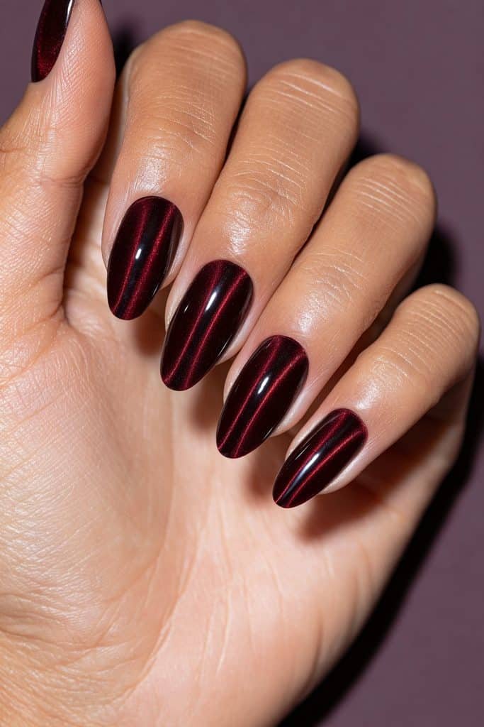 Maroon double cat eye nails with two parallel ruby-red magnetic streaks on each glossy burgundy nail.