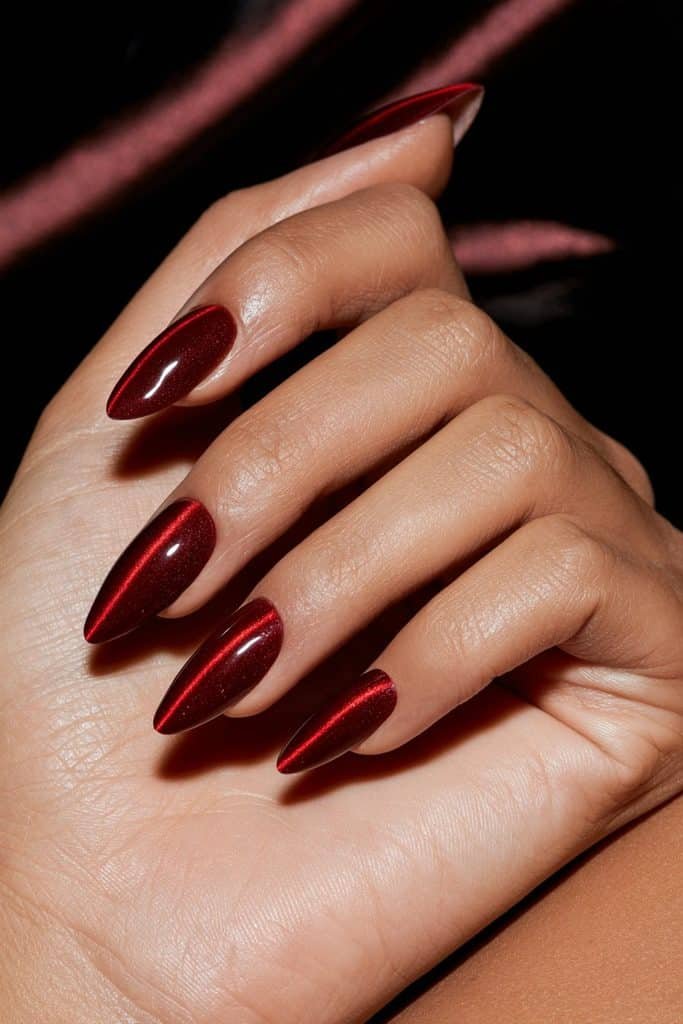 Double red cat eye nails featuring two parallel luminous ruby magnetic stripes on each glossy almond-shaped nail.
