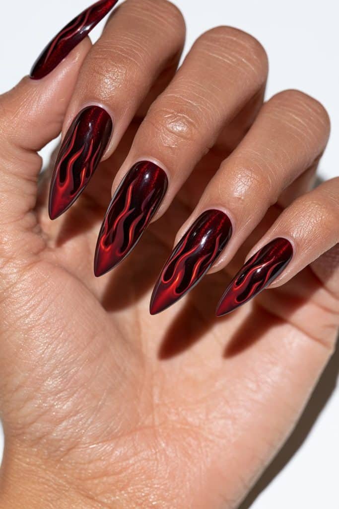 Maroon cat eye flame nails with dark cherry flame designs, glowing ruby highlights, and a glossy burgundy magnetic finish.
