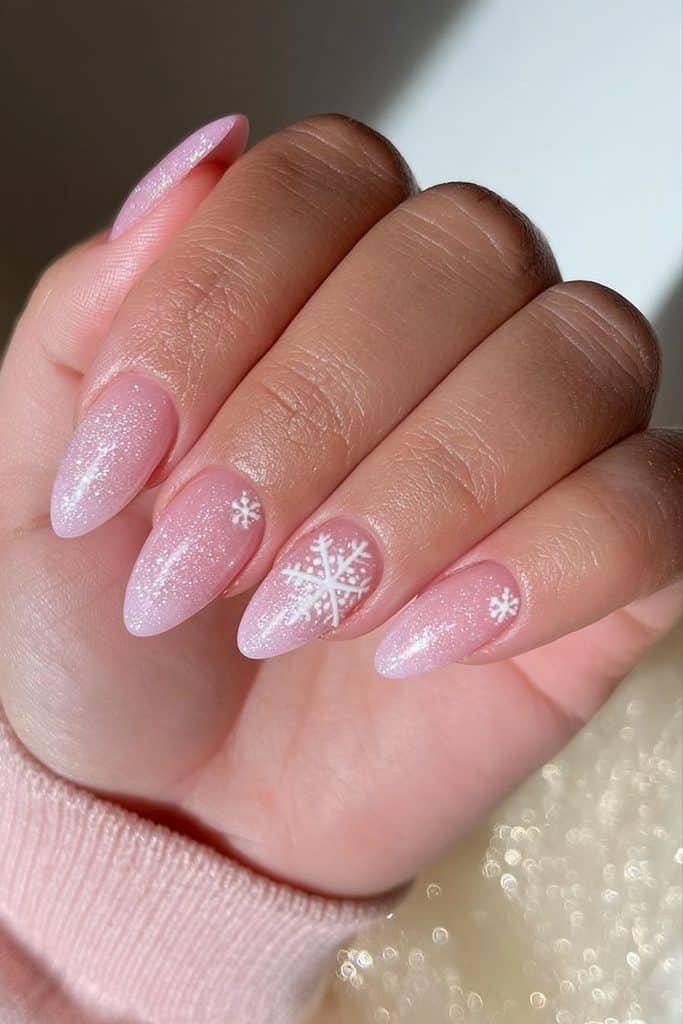 Frosted pale pink ski nails with a pearly sheen and delicate white snowflake accents