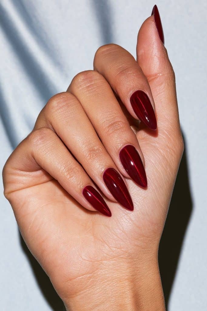 Glass red cat eye nails with translucent cherry jelly polish, reflective silver shimmer, and a glossy finish.