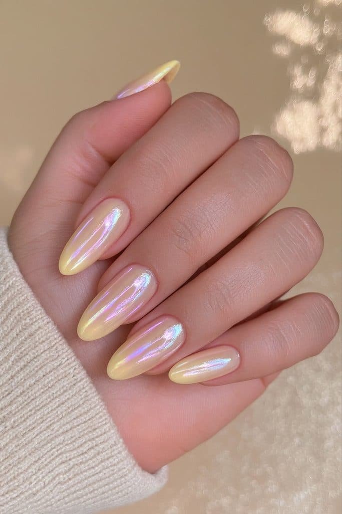 Glazed butter yellow nails with a pearly chrome overlay and luminous champagne reflections