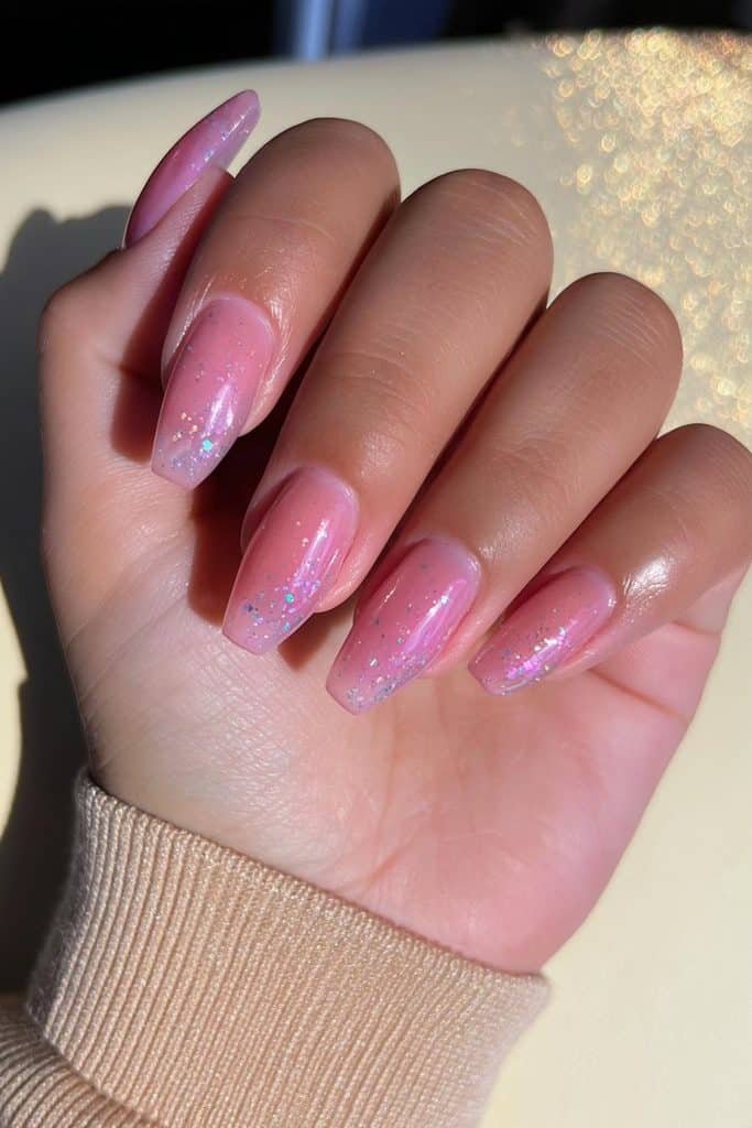 Rosy nude jelly nails with delicate champagne, silver, and pink micro glitter flecks