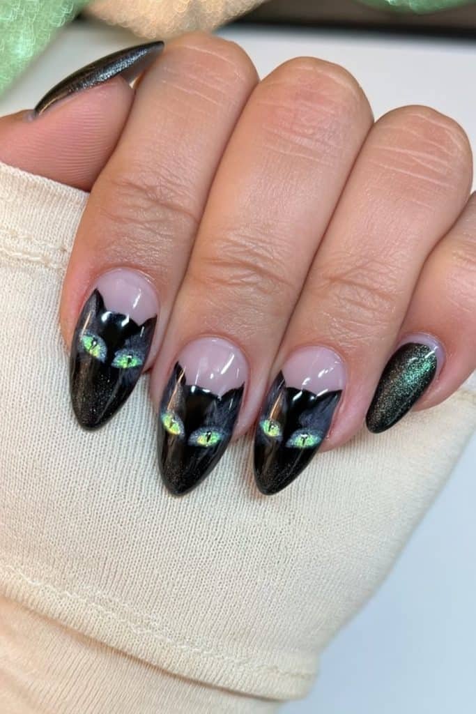 Glossy black cat nails featuring sleek silhouettes with vivid emerald-green eyes