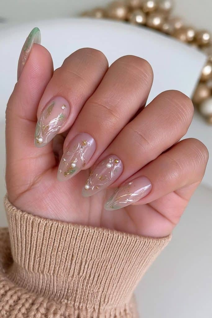 Milky nude nutcracker nails with delicate gold leaf, ivory pearls, and ornamental linework