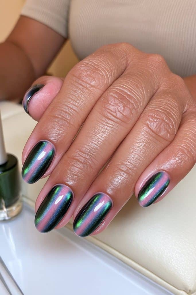 DIY hunter green cat eye gel nails with a clear emerald magnetic stripe and a neat, glossy oval shape.