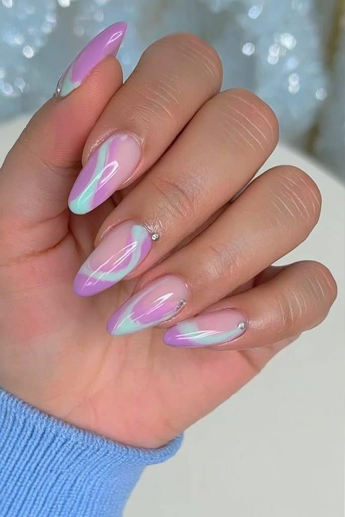Icy plum and sky-blue swirl nails over a translucent milky base with silver accents