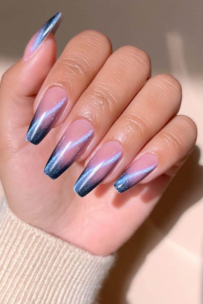 Indigo cat-eye ombré nails fading from dark navy edges to luminous cobalt centers