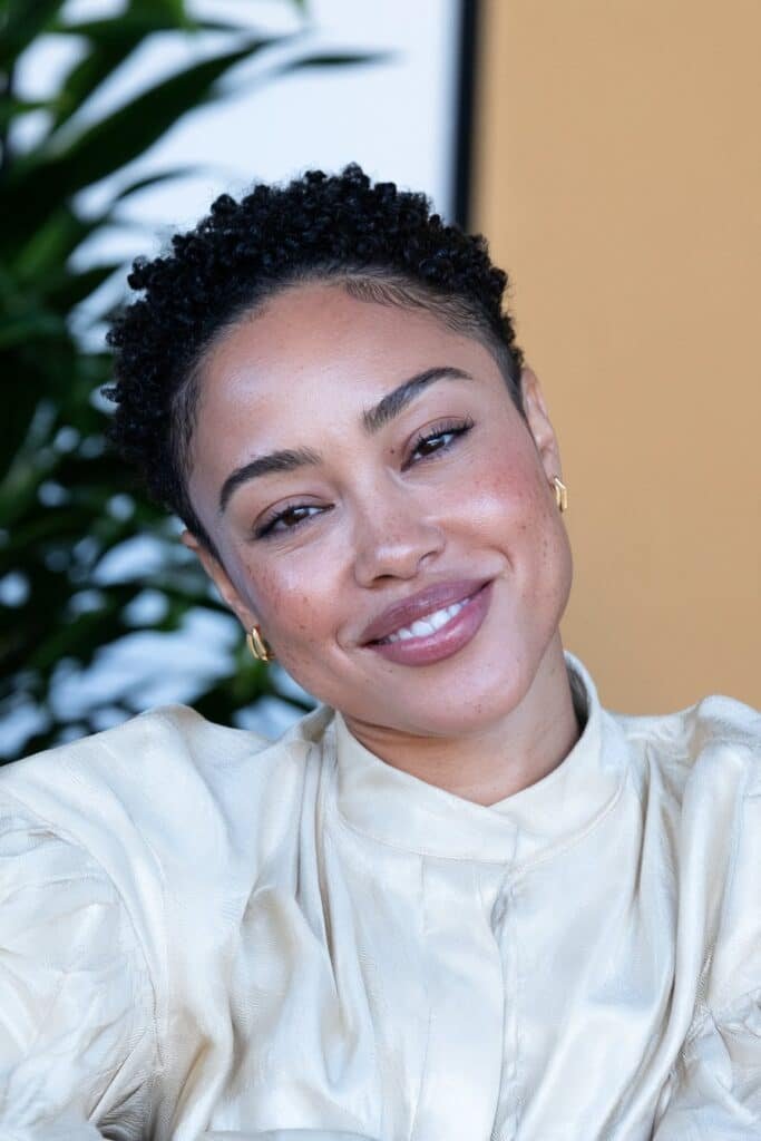 Black woman with a low taper fade haircut featuring neatly trimmed sides and natural textured hair on top.