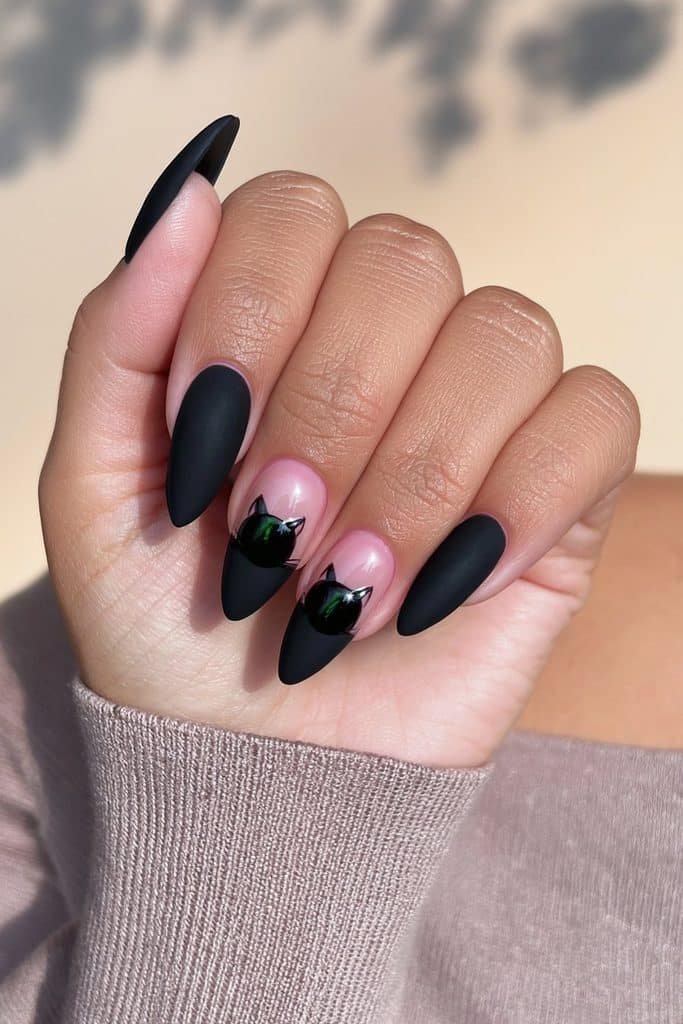 Matte black cat nails with subtle glossy cat silhouettes and flowing tails