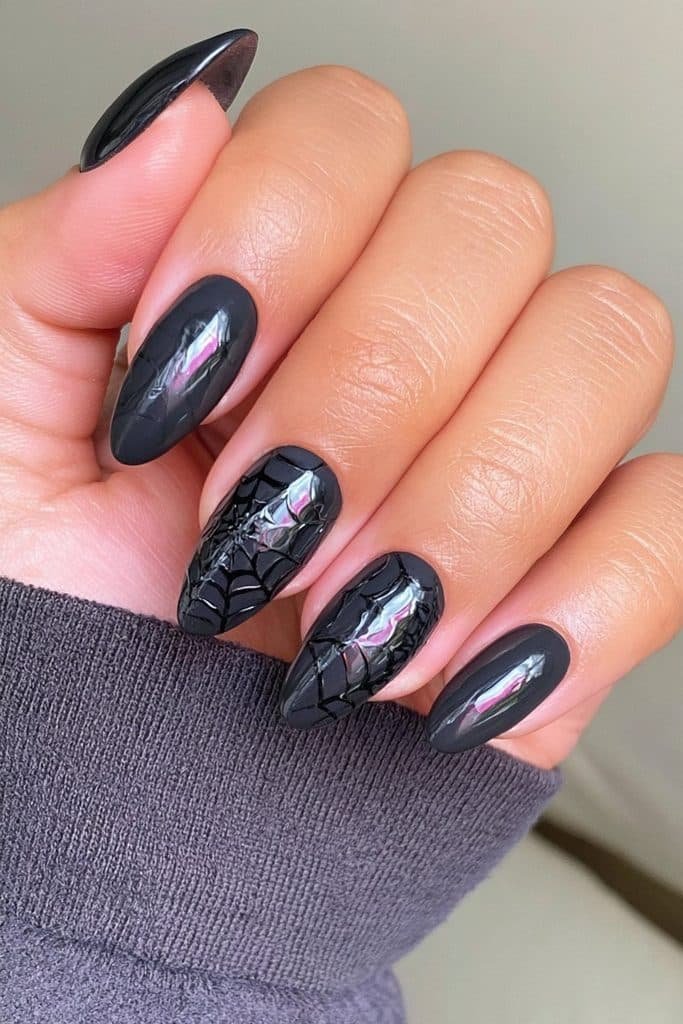 Matte black spider web nails with glossy black web accents and subtle tonal contrast