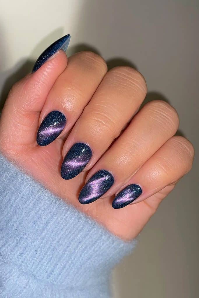 Matte dark blue cat-eye nails with subtle sapphire magnetic bands beneath a velvety finish
