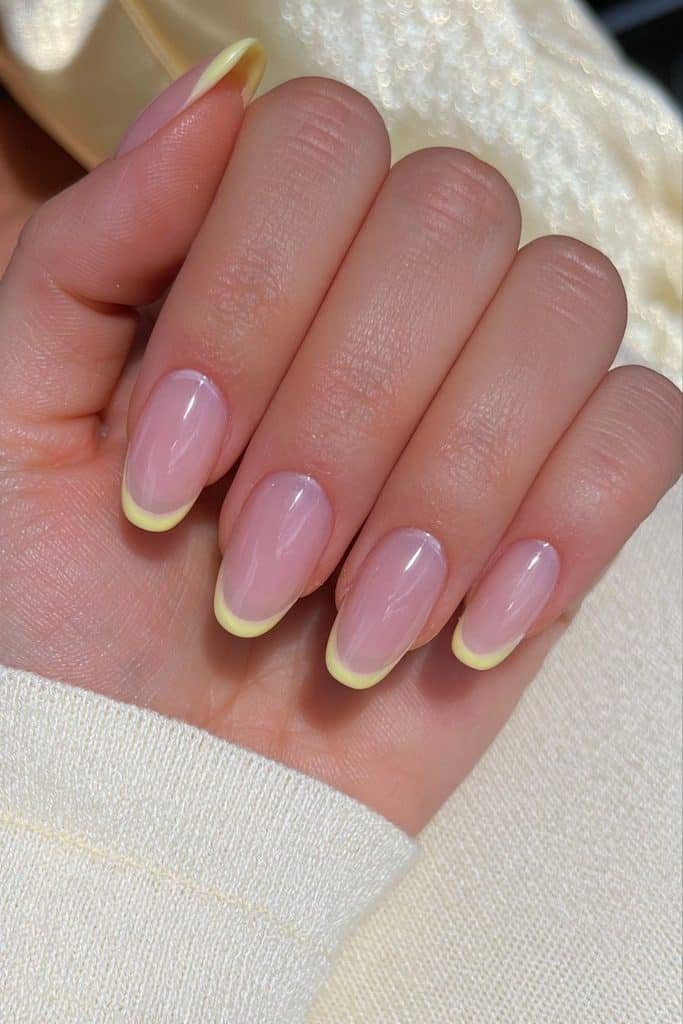 Short butter yellow micro French nails with ultra-thin yellow tips and a sheer pink base