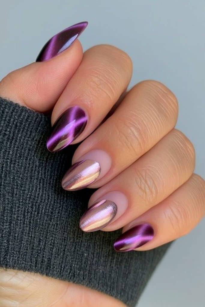 Midnight violet cat-eye nails with luminous purple trails and a silver-lilac chrome accent