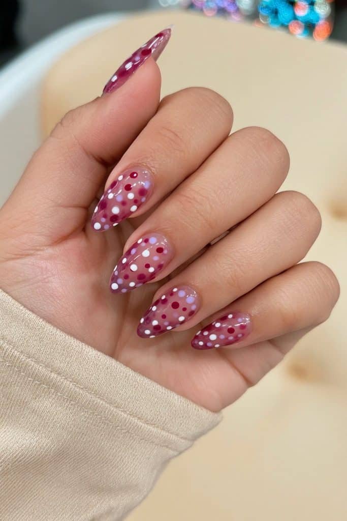 Sheer pink jelly nails with tiny white, cherry red, and lavender polka dots