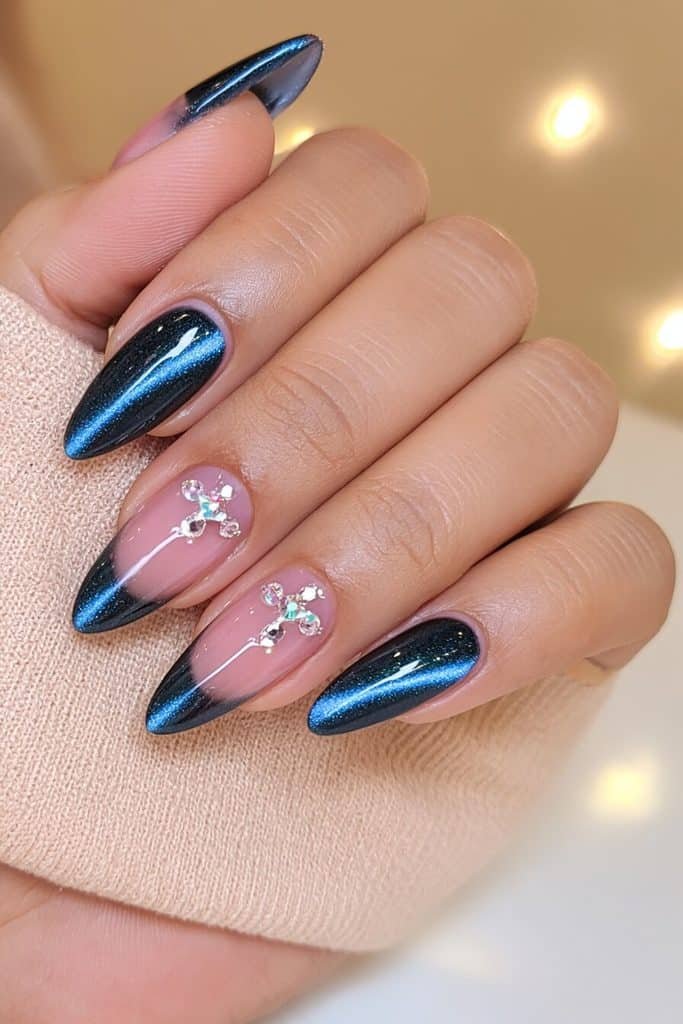Navy cat-eye nails with luminous cobalt ribbons and delicate clear rhinestone cuticle accents