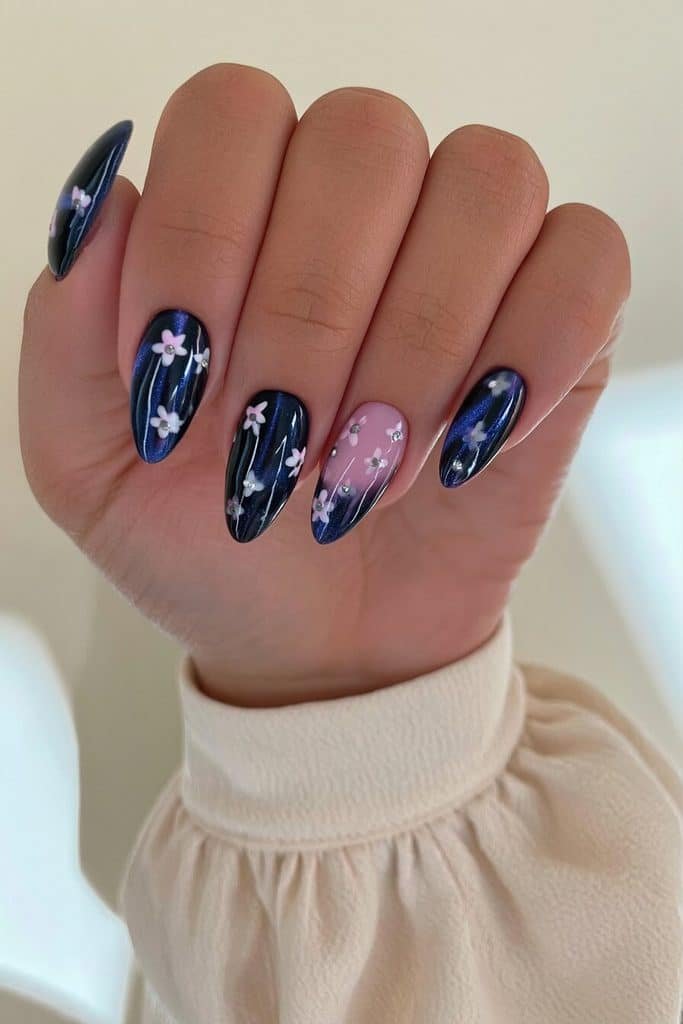 Navy cat-eye nails with sapphire shimmer and tiny white floral accents with silver centers