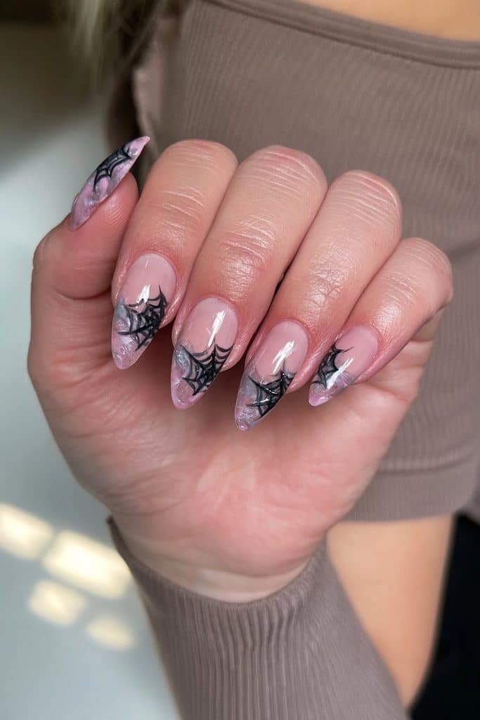 Minimalist spider web nails with fine black lines over a sheer transparent base
