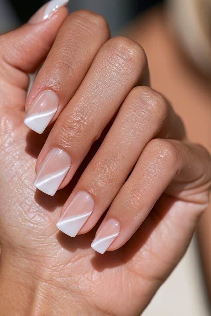 Negative space white cat eye nails featuring transparent sections and luminous magnetic stripes