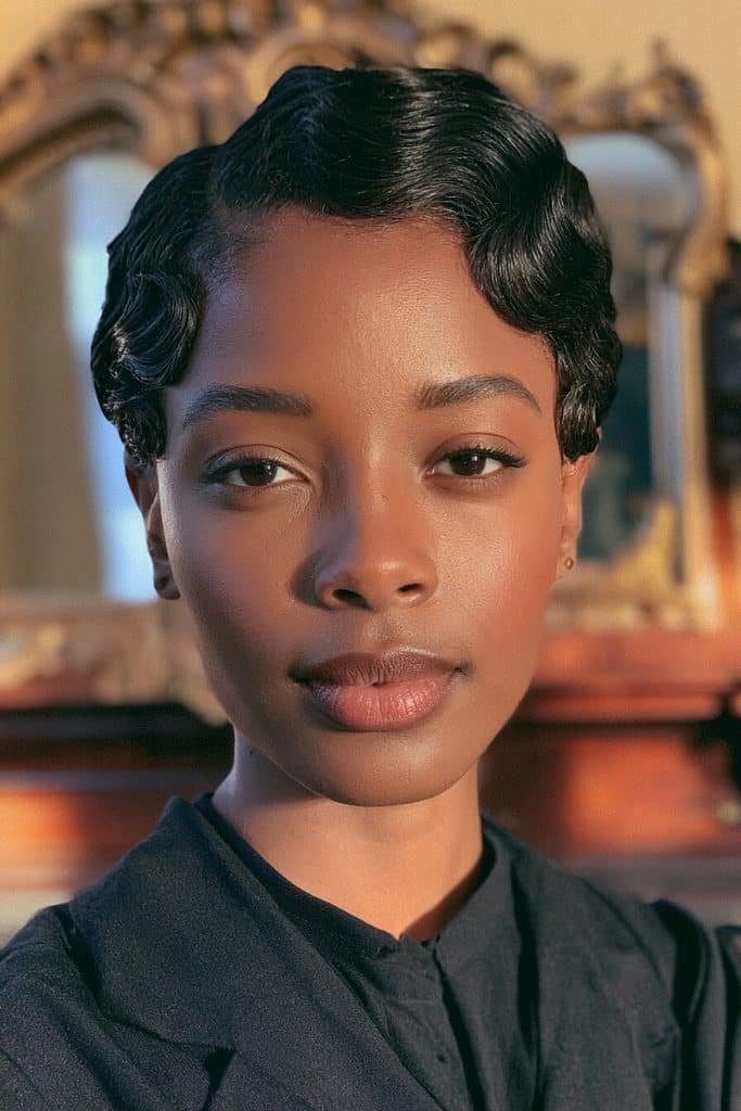 Old Hollywood finger wave pixie cut for Black women with elegant S-shaped waves and a vintage sculpted finish.