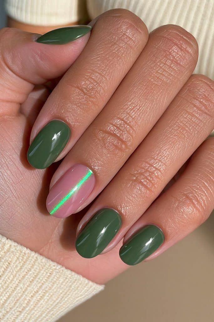 Short oval dark green nails with one emerald cat eye accent nail featuring a bright magnetic shimmer stripe.