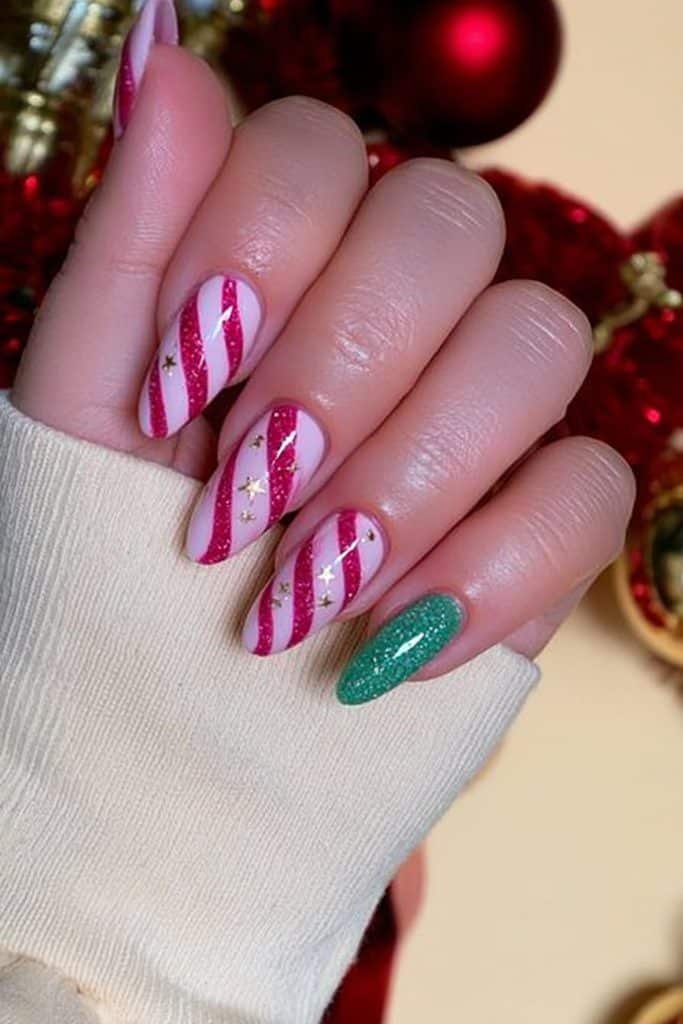 Milky white peppermint swirl nails with ruby-red stripes and tiny gold Christmas stars