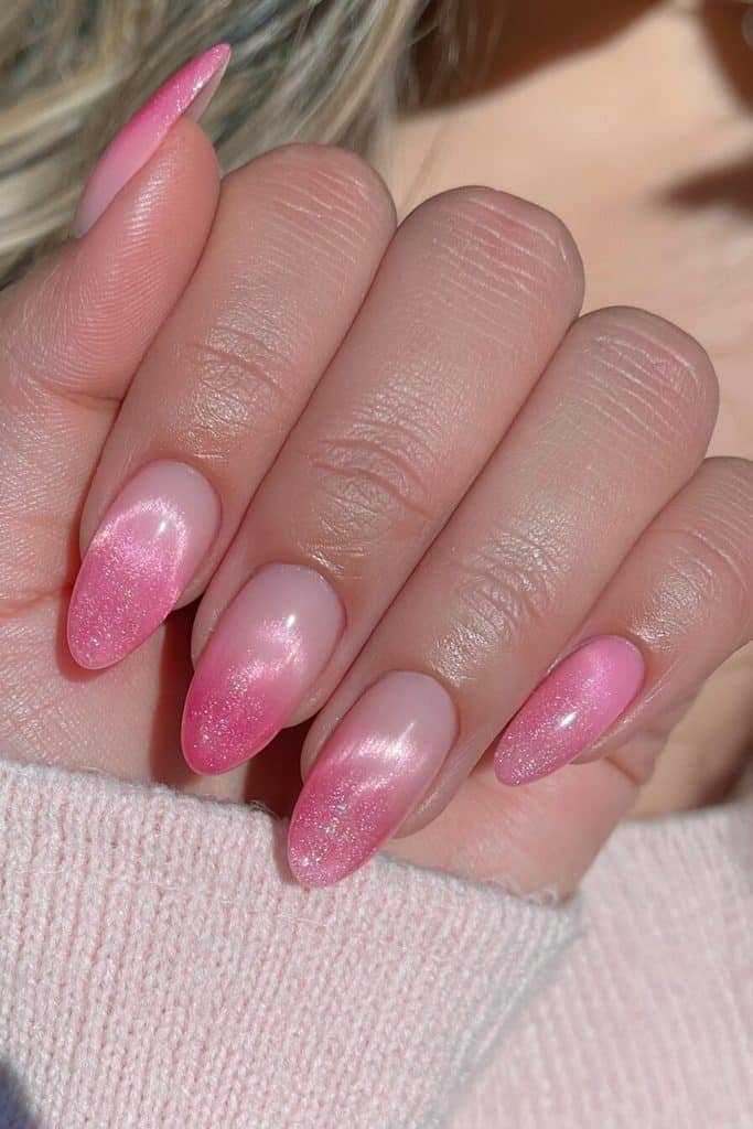 Pink aura cat-eye nails with glowing baby-pink centers, rosy gradients, and pearly magnetic highlights