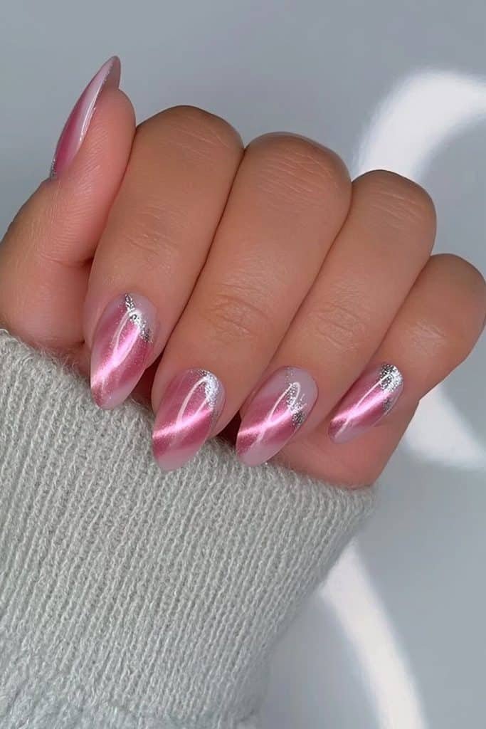 Pink cat-eye nails with luminous rosy bands and reflective silver-chrome accents on selected tips
