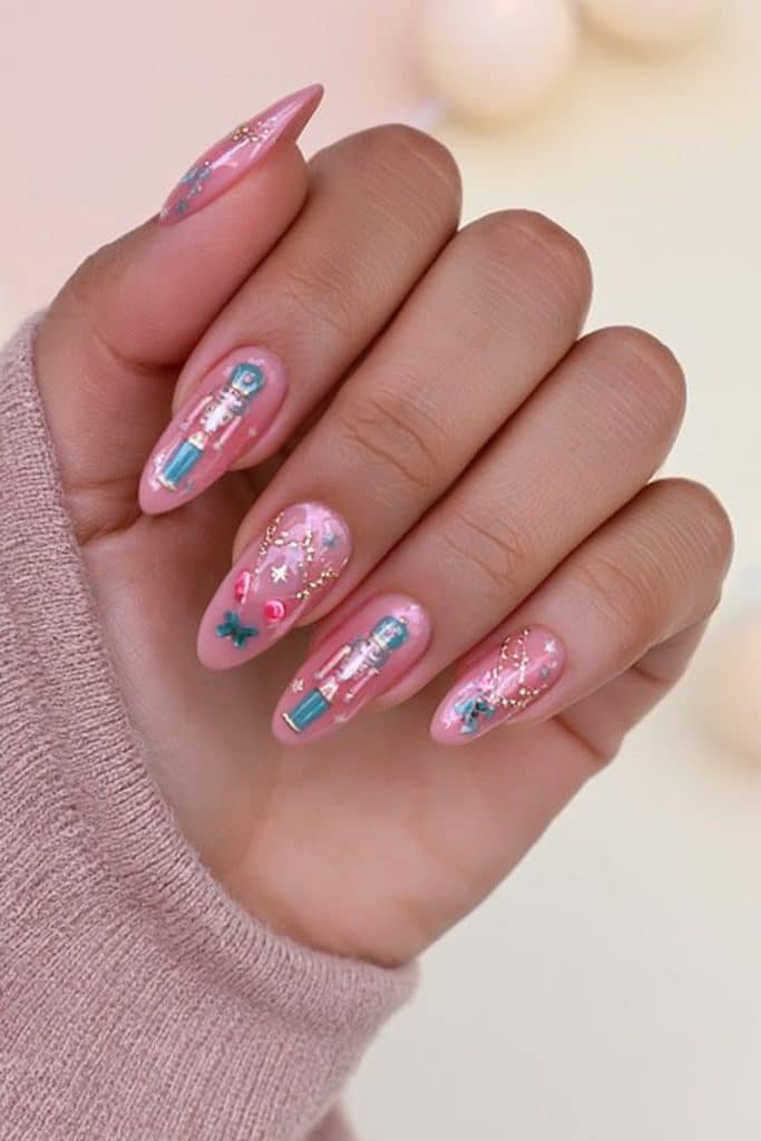 Pastel pink and muted teal nutcracker nails with champagne-gold buttons and festive stars