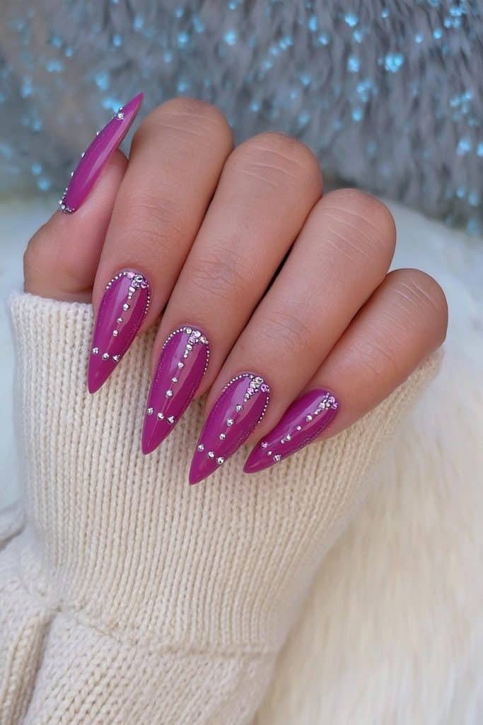 Rich sugar plum almond nails with delicate silver rhinestones and crystal accents