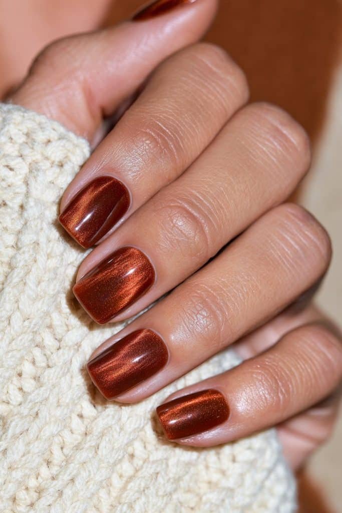 Pumpkin spice burnt orange nails with soft square tips and dimensional velvet shimmer.