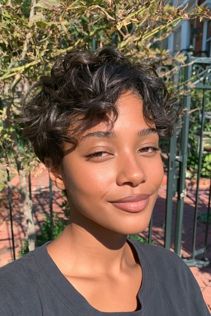 Relaxed wavy pixie cut for Black women with soft sweeping waves, tapered sides, and natural dark hair.