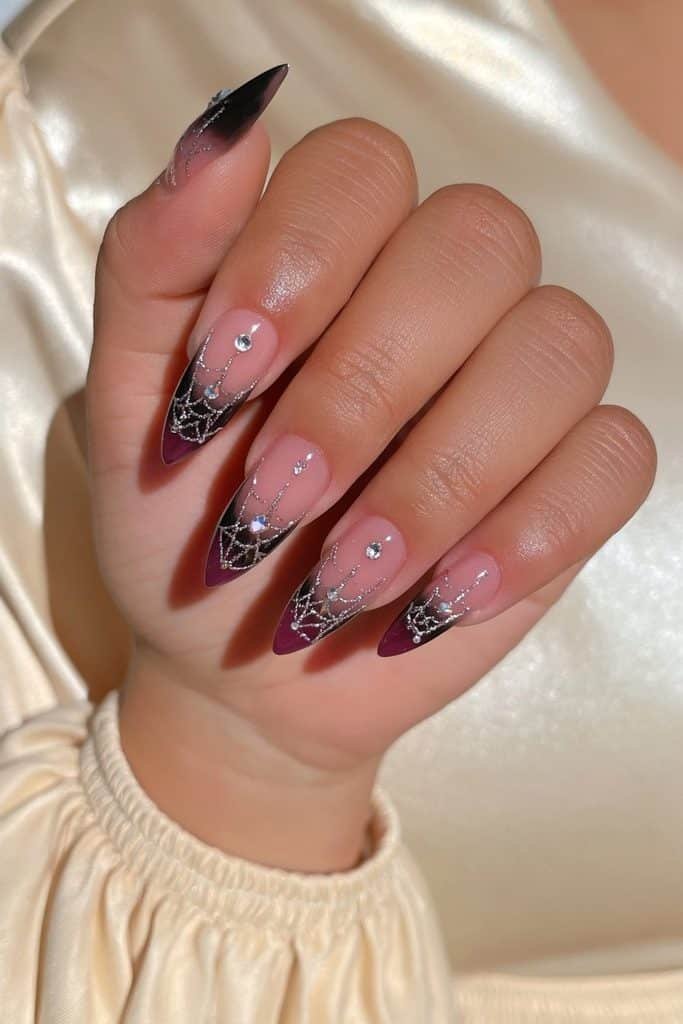 Black and blush-pink spider web nails embellished with fine silver lines and tiny clear rhinestones