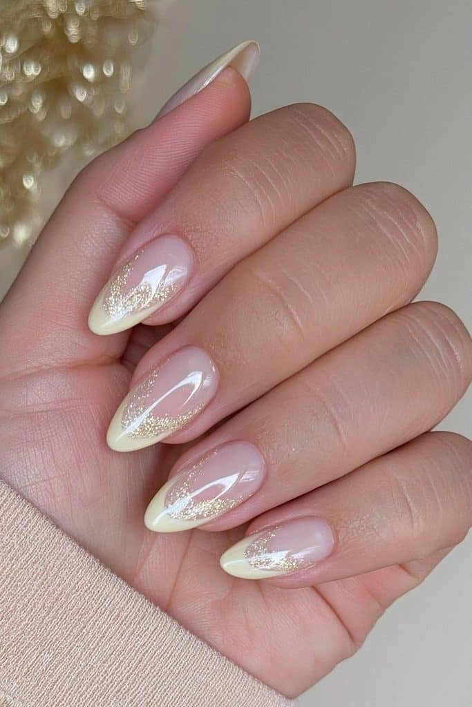 Shimmery butter yellow nails with fine champagne micro-glitter and a luminous glossy finish