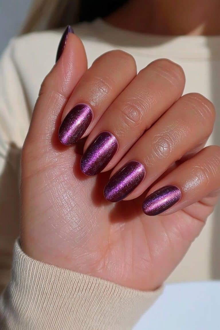 Short oval dark purple cat-eye nails with fine violet magnetic bands and glossy polish
