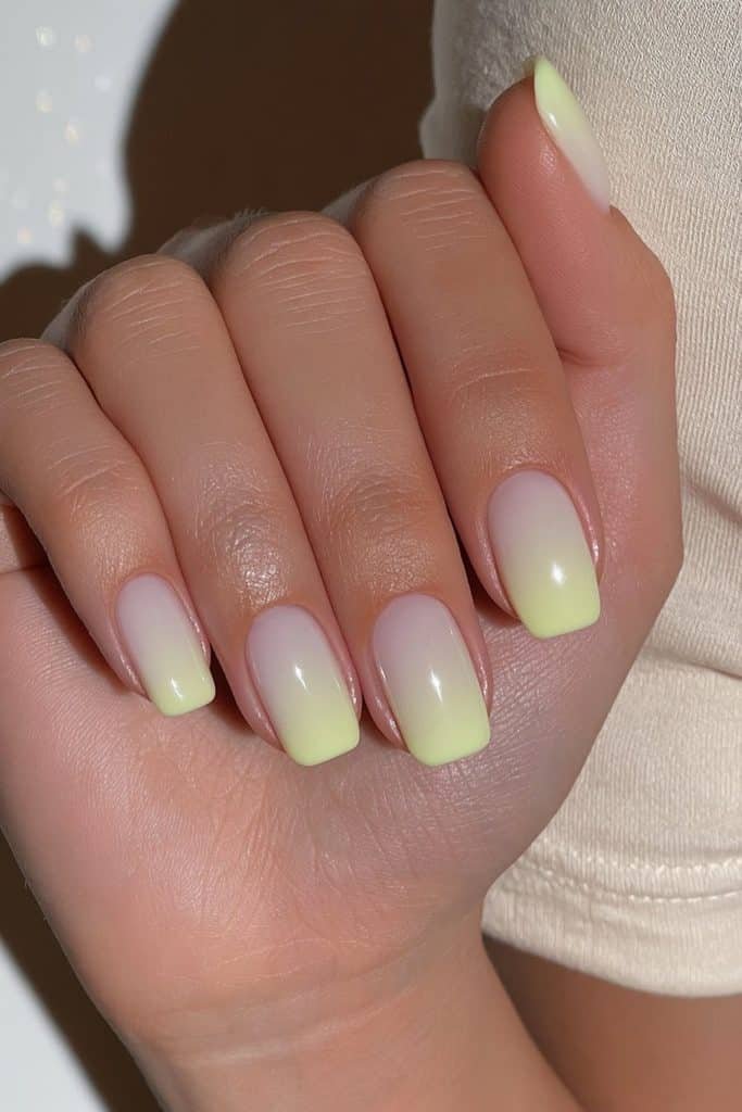 Short squoval butter yellow nails with softly rounded square edges and glossy pastel polish