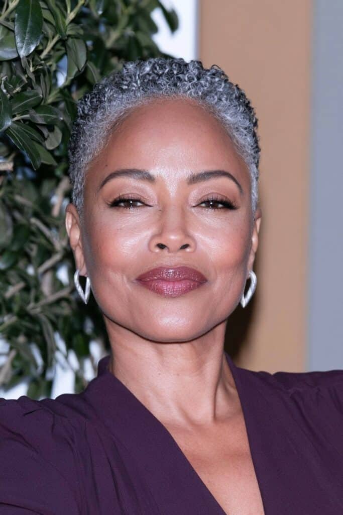 Black woman with a silver tapered haircut featuring short, textured curls and softly faded sides.