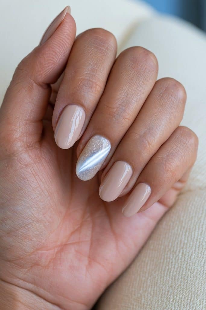White cat eye accent nail with a luminous magnetic stripe paired with glossy neutral beige-pink nails