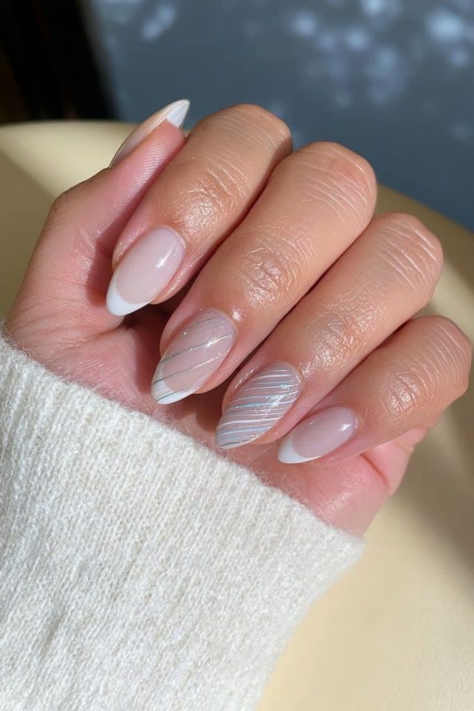 Minimalist white ski nails with curved icy blue and silver lines inspired by ski tracks