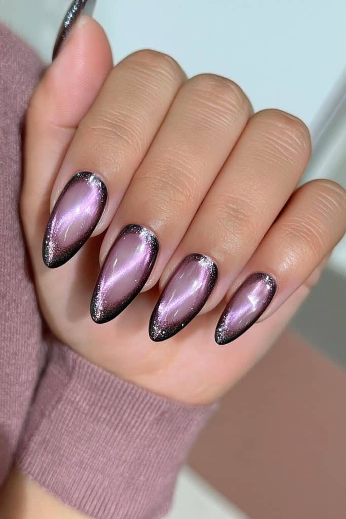Smoky grape cat-eye nails with charcoal-purple edges and glowing violet streaks