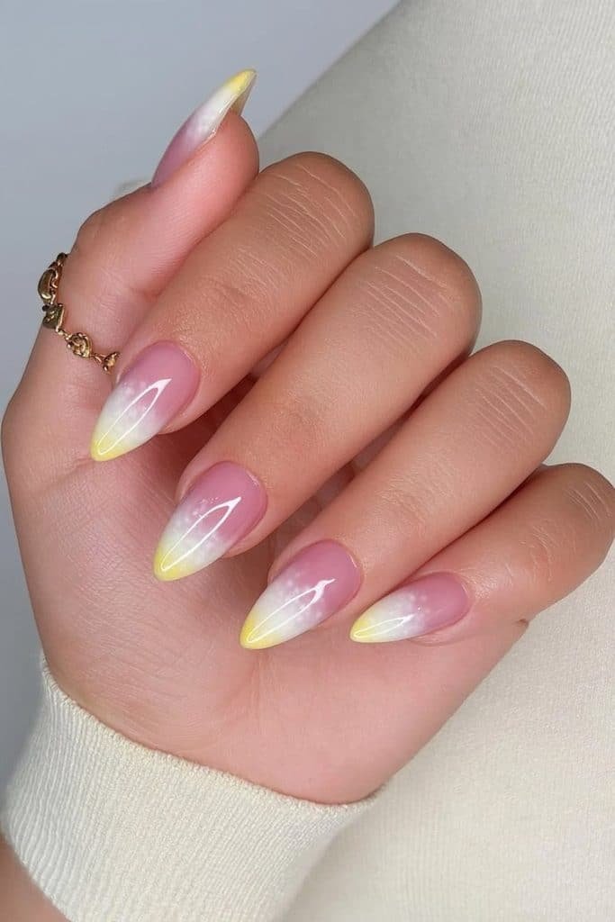 Soft butter yellow aura nails with a diffused yellow glow over a sheer milky-white base