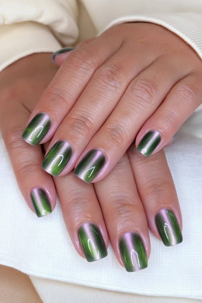 Short squoval dark green cat eye nails with softly squared tips, rounded corners, and centered emerald shimmer.