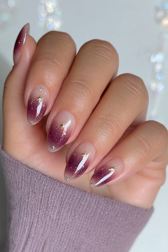 Sugar plum purple aura nails with a milky pink base, tiny gold stars, and silver sparkle