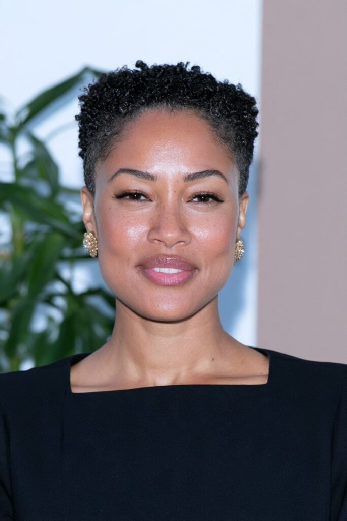 Black woman with a stylish tapered pixie cut featuring short sides and soft, textured curls on top.