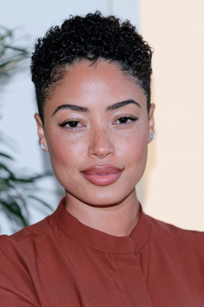 Black woman with a tapered teeny weeny afro (TWA), showcasing short natural coils and neatly tapered sides.
