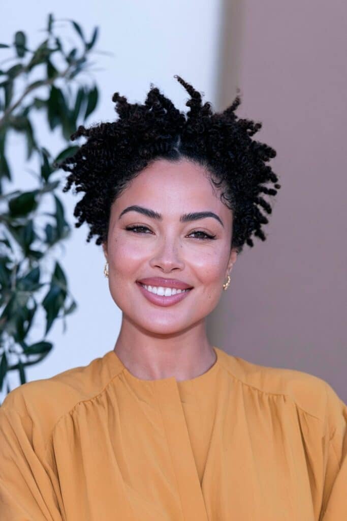 Black woman with a tapered twist-out hairstyle featuring separated, defined curls on top and short tapered sides.