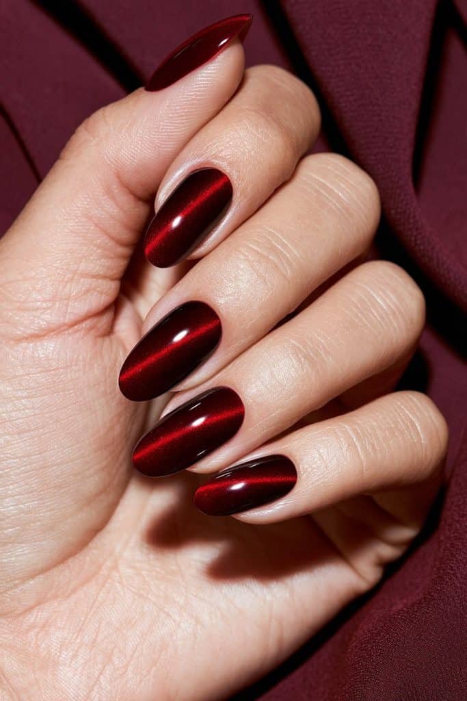 Velvet red cat eye nails with a rich crimson magnetic glow and a deep, luxurious crushed-velvet effect.