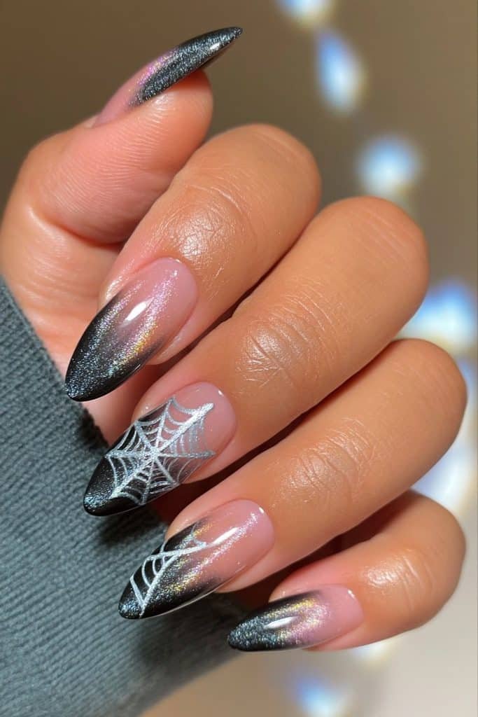 Black velvet cat-eye nails with delicate silver spider web designs and magnetic shimmer