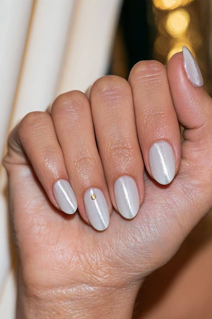 White cat eye nails with reflective magnetic stripes and delicate gold foil accents